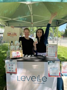 Two female employees of Levelle Nutrition standing behind their booth at a tradeshow event