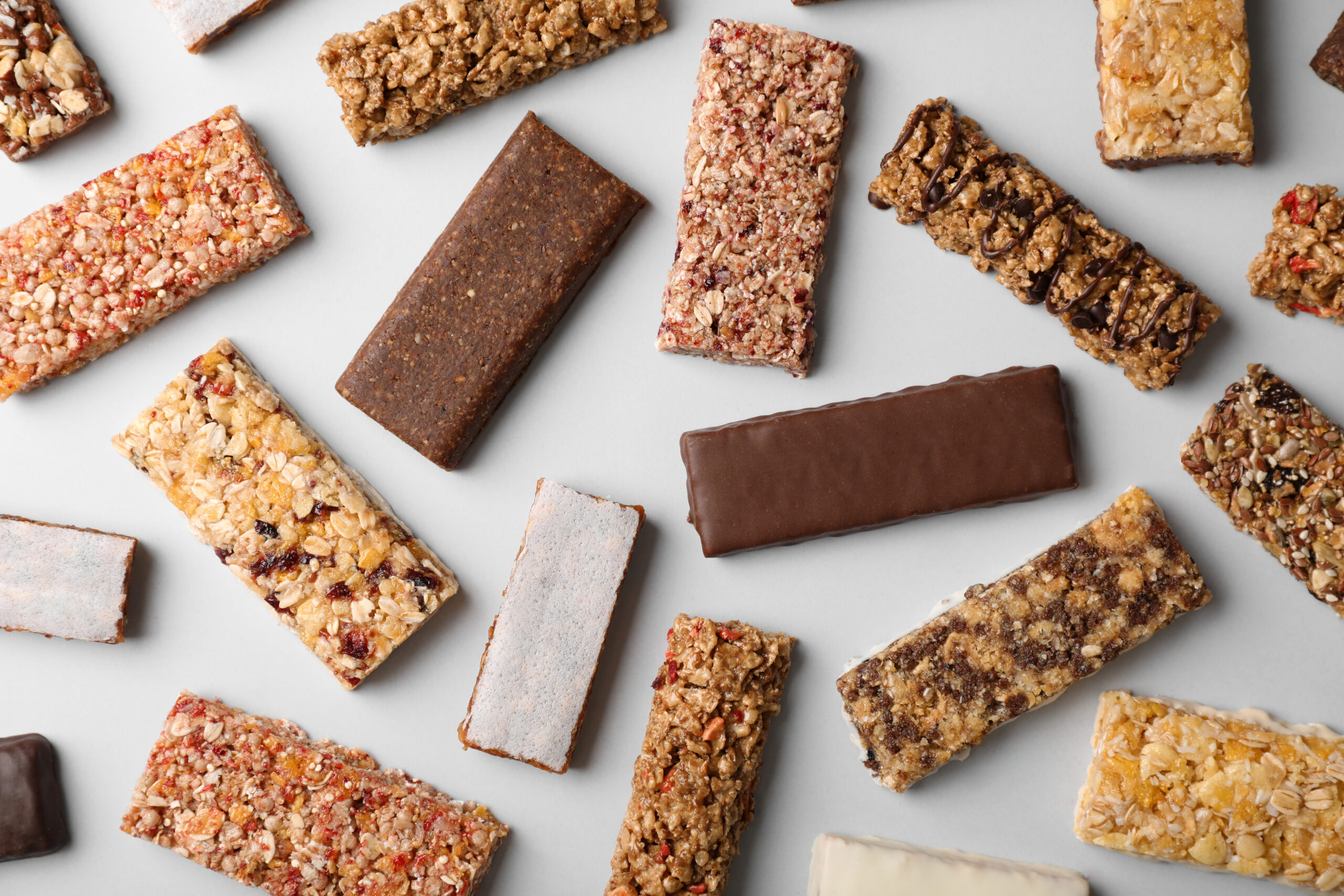 Flat lay composition with protein bars on grey background